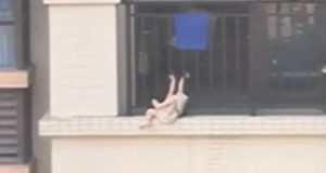 شاب صينى ينقذ طفلة قبل سقوطها من شرفة منزلها بالطابق السابع.. فيديو وصور
